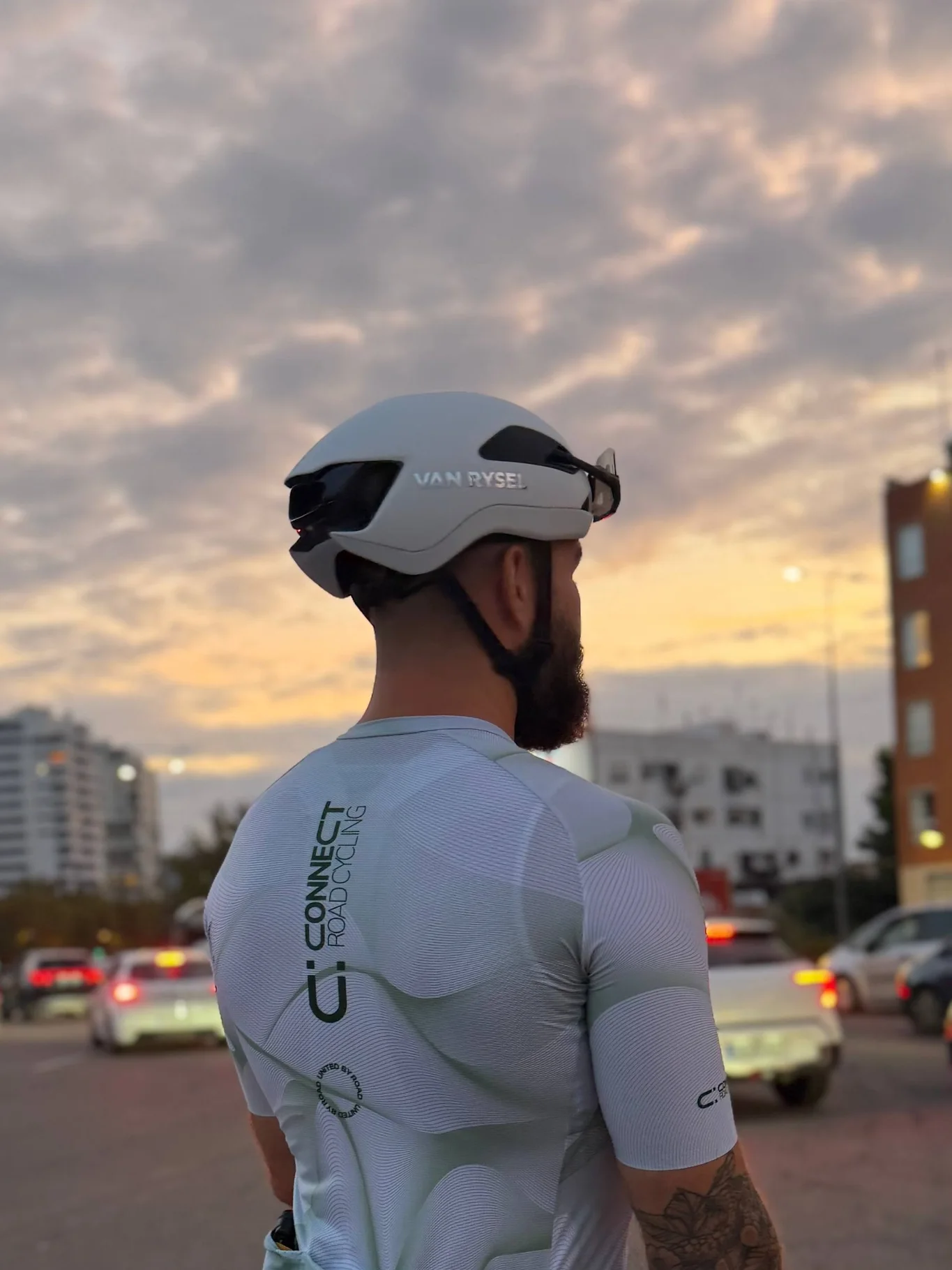 Cyclist photographed from behind wearing a CONNECT Road Cycling branded jersey at sunset.